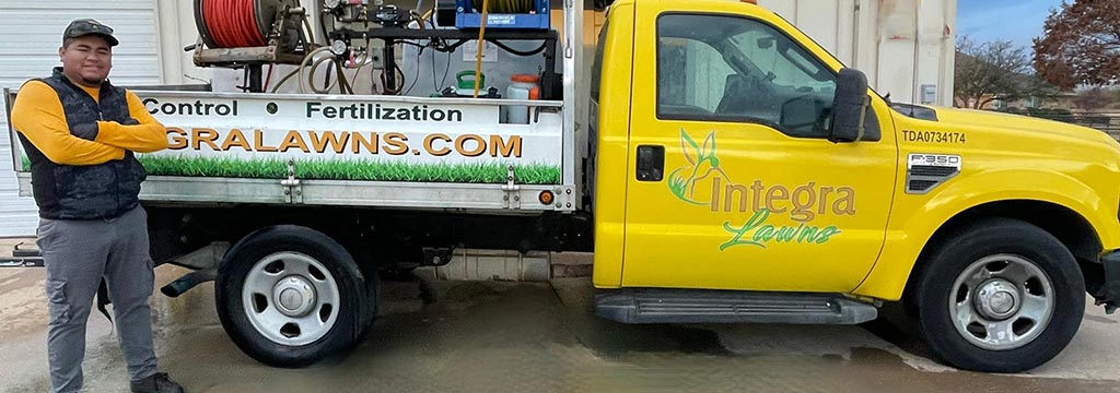Integra Pest & Lawn Employee posed with work truck in Arlington, TX.