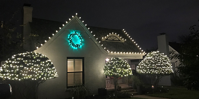 Christmas lights installed over residential's landscape in Fort Worth, TX.